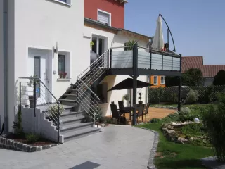 Balkonanlage-verzinkt-pulverbeschichtet-mit-Milchglasgelaender-Laerchen-Belag-und-integriertem-Treppenaufgang-scaled