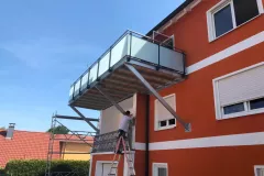 Balkonerweiterung-verzinkt-mit-Milchglasgelaender-und-Laerchen-Belag-scaled