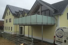 Stahlbalkon-verzinkt-mit-Milchglasgelaender-und-Holz-Belag-scaled